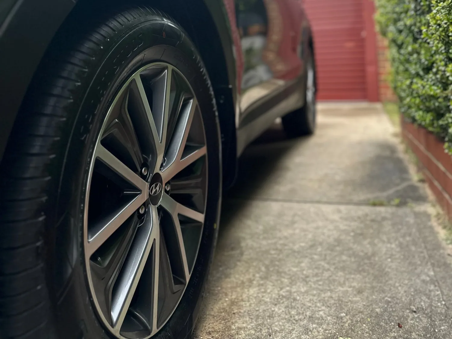 The wheel and glossy grey paint of a Hyundai Santa Fe on a driveway
