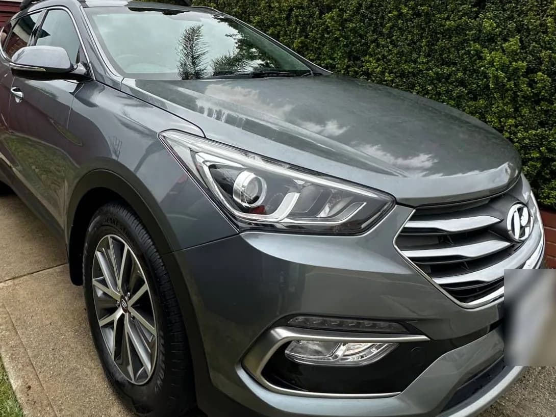A grey Hyundai Santa Fe parked on a home driveway