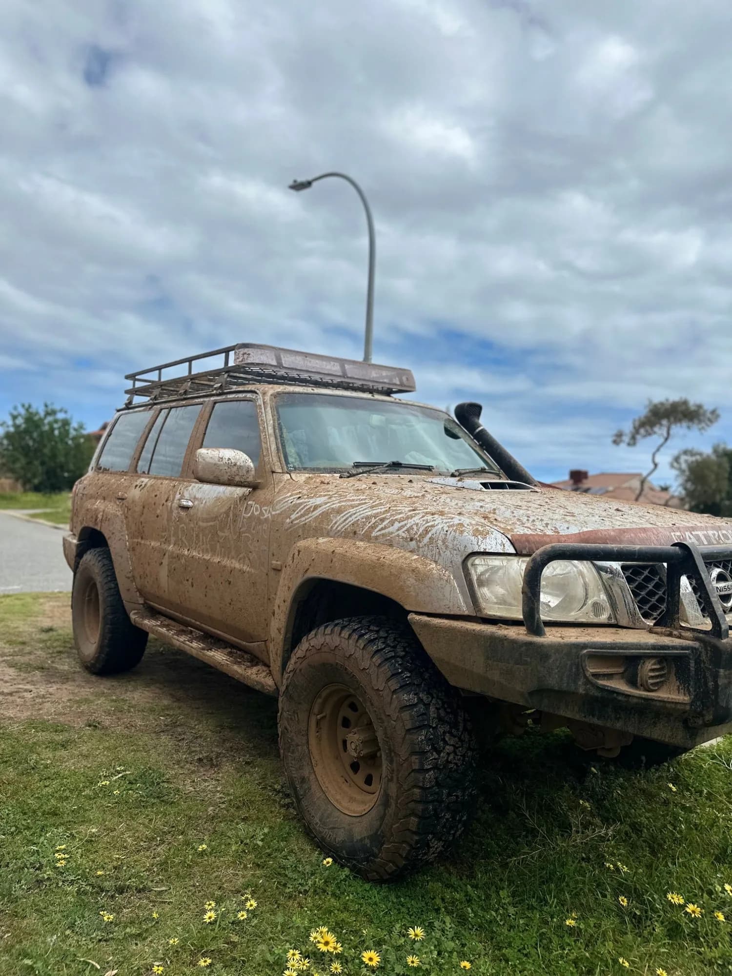 The front of the Nissan Patrol covered in mud, before detailing