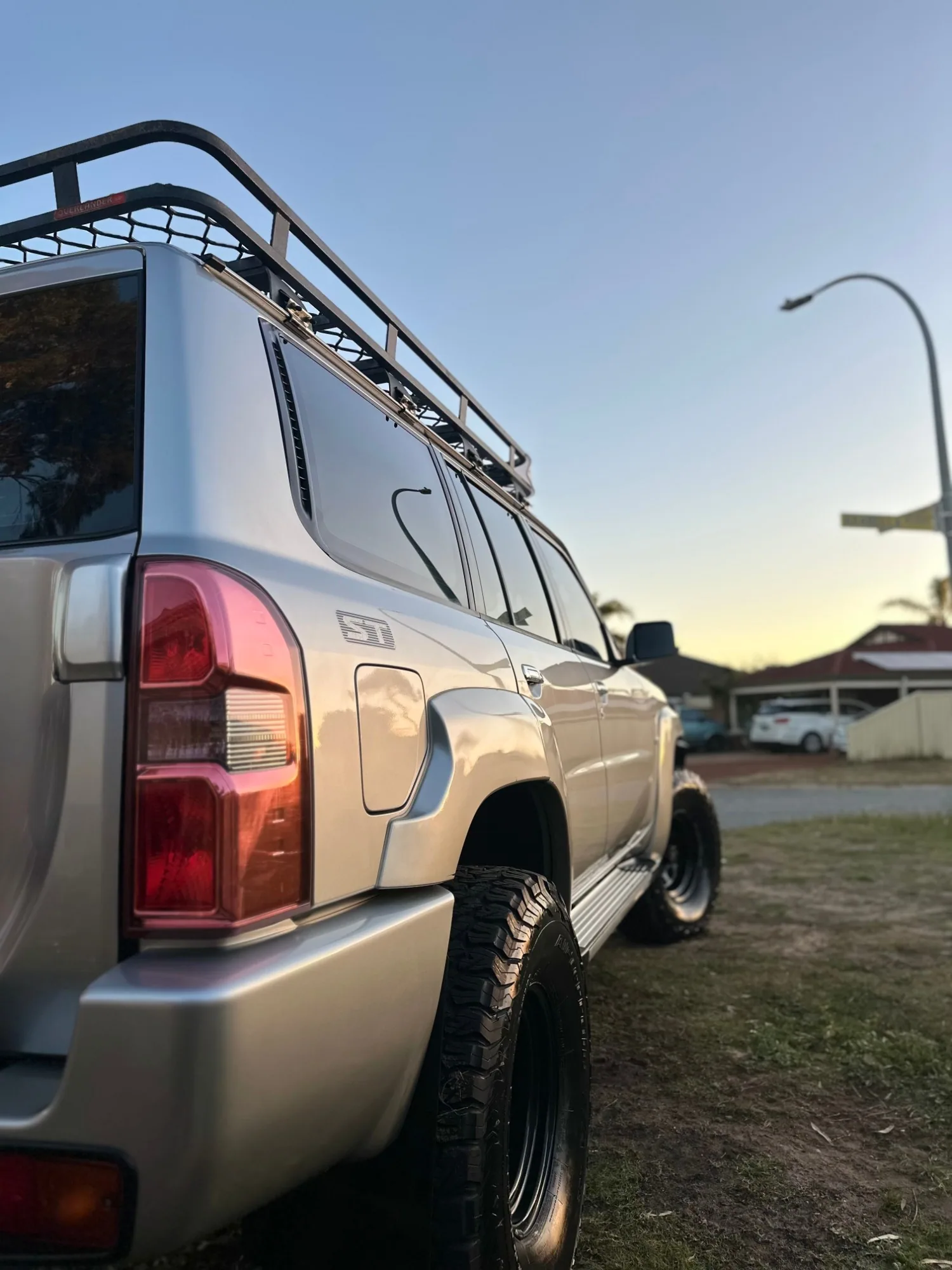 The same Nissan Patrol after detailing, with clean silver paint at sunset