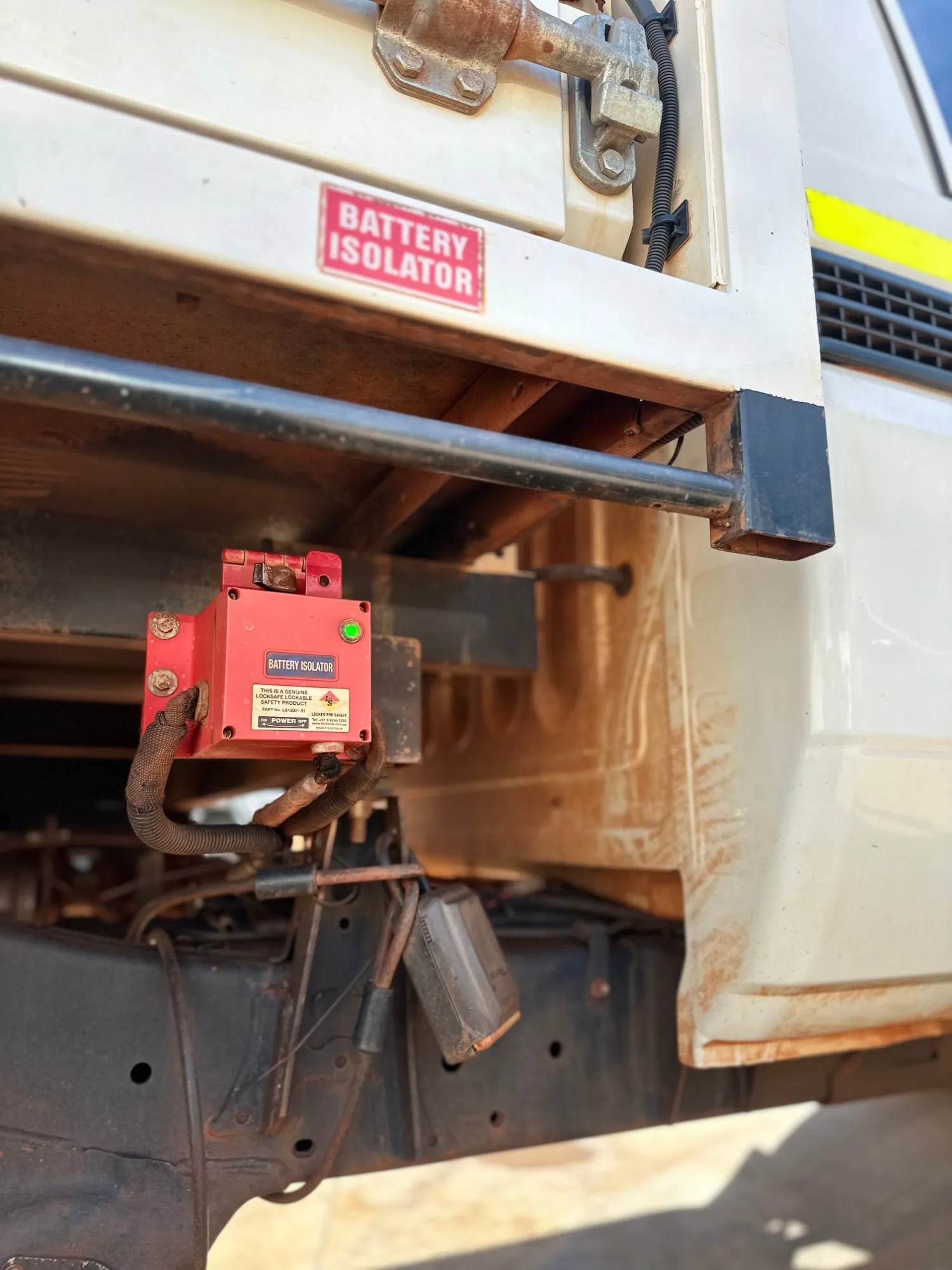 Red dust on the side and underside of a white work ute, before detailing